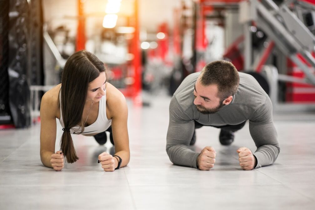 男性と女性がすべての筋肉群のために設計された板の運動を行います